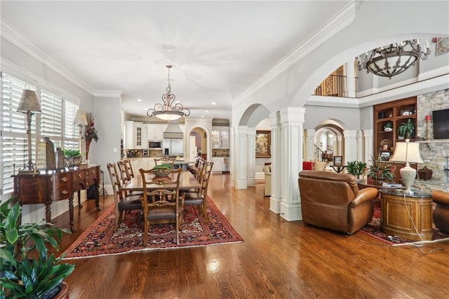 dining area with ornate columns, hardwood / wood-style flooring, and crown molding