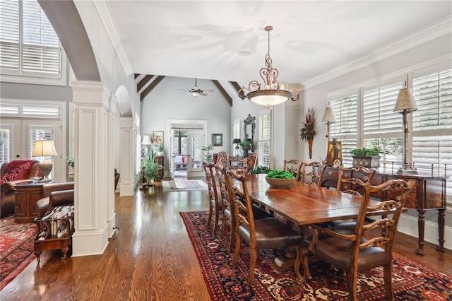 dining space featuring dark wood-type flooring, lofted ceiling, ornamental molding, ceiling fan, and ornate columns