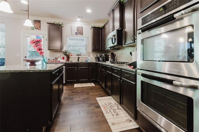 3241 Alhambra Cir, Hampton, GA 30228 - kitchen with visible vents, dark wood-type flooring, tasteful backsplash, light stone counters, and appliances with stainless steel finishes
