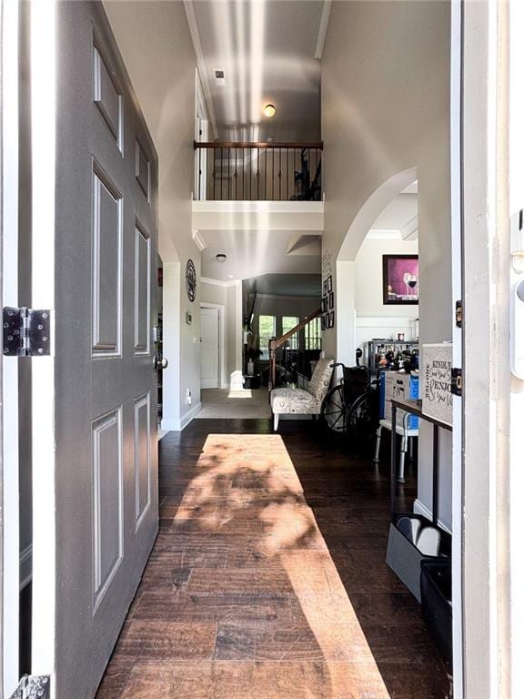 3241 Alhambra Cir, Hampton, GA 30228 - foyer entrance with dark wood-type flooring, arched walkways, a towering ceiling, and ornamental molding
