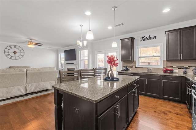 kitchen featuring a kitchen island, sink, pendant lighting, and light hardwood / wood-style floors