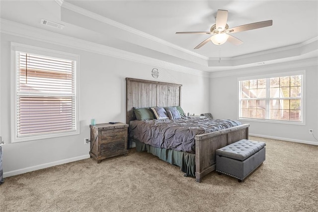 carpeted bedroom featuring a raised ceiling, ornamental molding, and ceiling fan