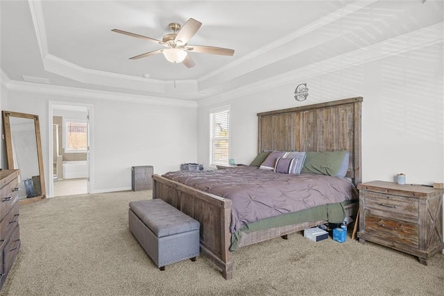 carpeted bedroom with ceiling fan, ornamental molding, a tray ceiling, and connected bathroom