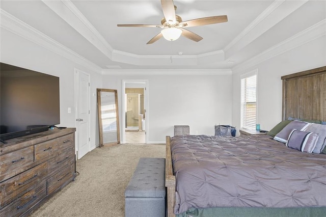 bedroom with crown molding, ensuite bath, ceiling fan, a tray ceiling, and carpet floors