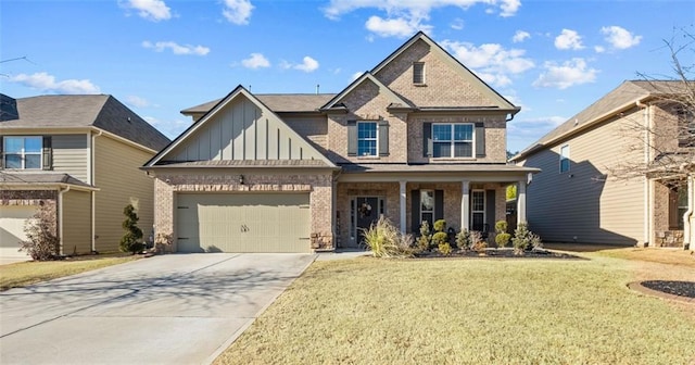 view of front of home featuring a garage, a front yard, and covered porch