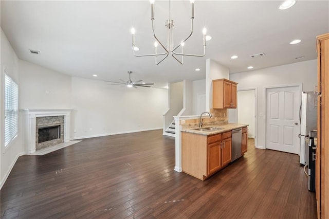kitchen featuring visible vents, open floor plan, a sink, ceiling fan with notable chandelier, and dishwasher