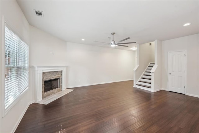 unfurnished living room featuring visible vents, a ceiling fan, dark wood-type flooring, and stairway