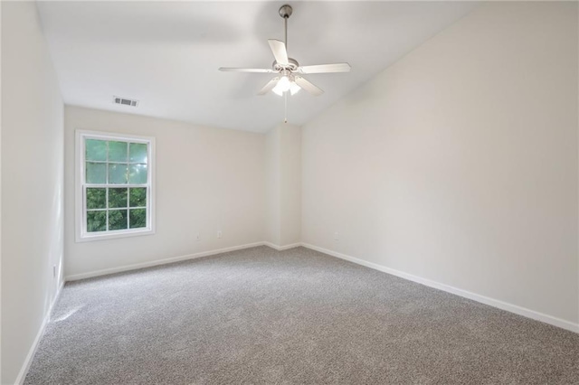 unfurnished room featuring visible vents, lofted ceiling, baseboards, ceiling fan, and carpet flooring
