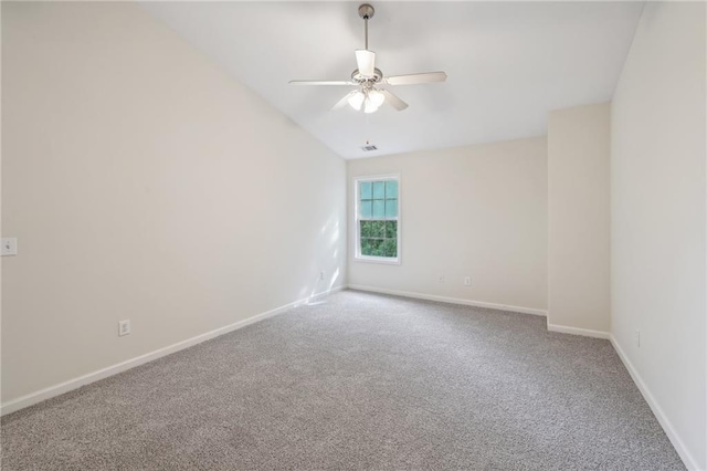 carpeted spare room featuring baseboards, ceiling fan, vaulted ceiling, and visible vents