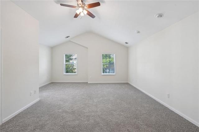 spare room featuring carpet floors, ceiling fan, lofted ceiling, and visible vents