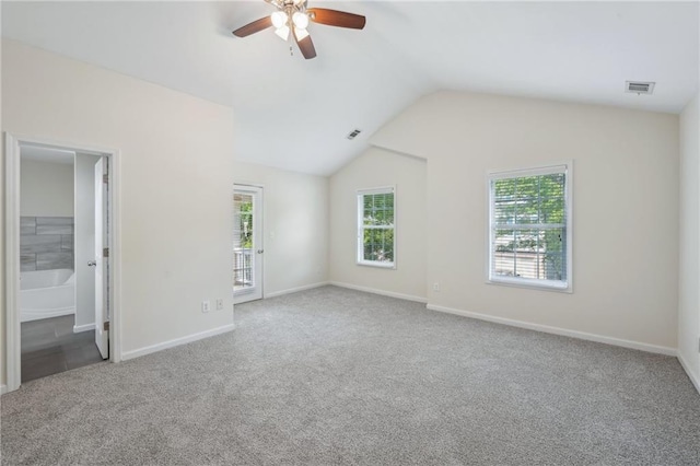 unfurnished bedroom with carpet floors, visible vents, multiple windows, and lofted ceiling