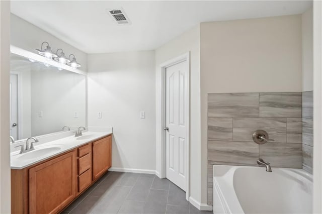 bathroom featuring a bathing tub, visible vents, a sink, and tile patterned flooring