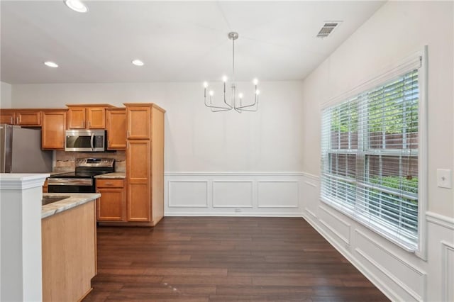 kitchen with visible vents, dark wood-style flooring, wainscoting, a notable chandelier, and stainless steel appliances