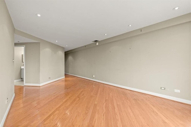 empty room featuring light wood-style floors, baseboards, and recessed lighting