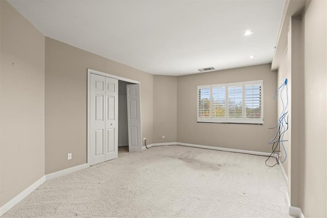 empty room with recessed lighting, light colored carpet, and baseboards