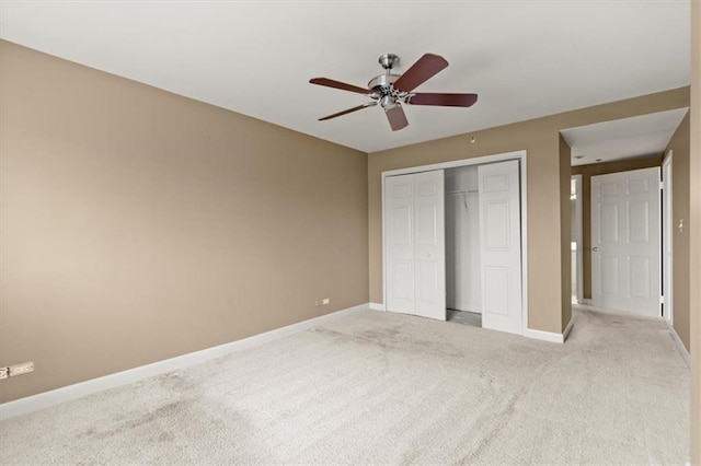 unfurnished bedroom featuring a closet, light colored carpet, ceiling fan, and baseboards