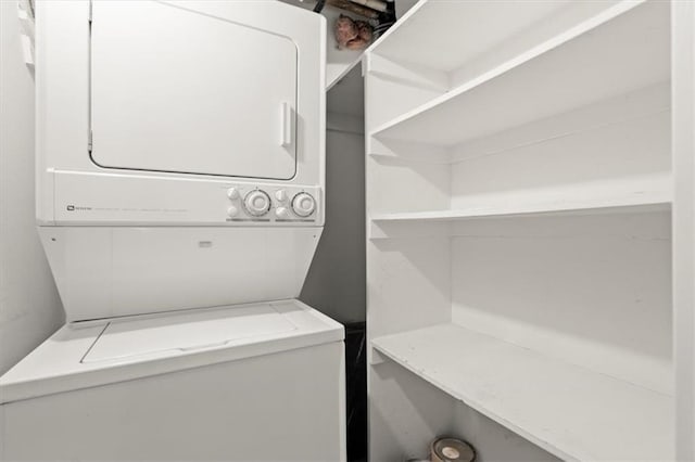 clothes washing area with stacked washer and dryer and laundry area