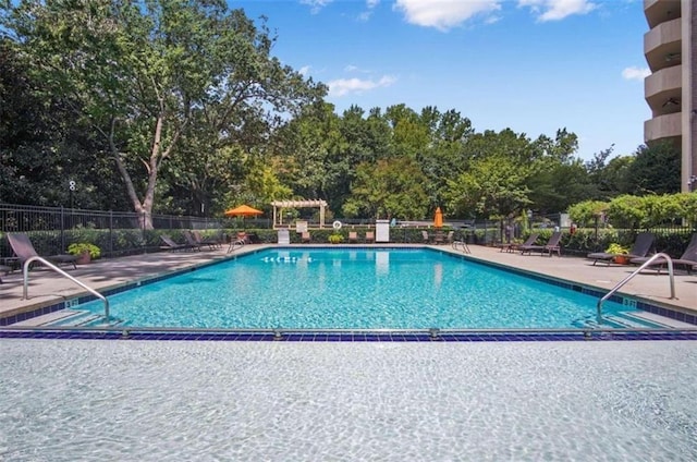 community pool with a patio area, fence, and a pergola