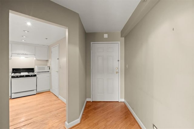 corridor with light wood finished floors and baseboards