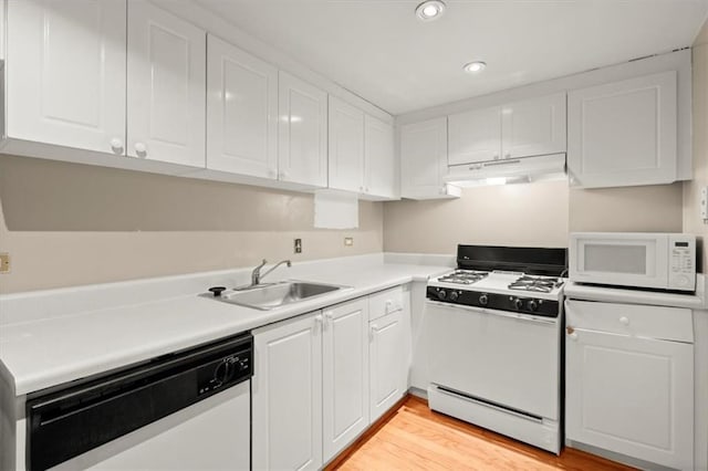 kitchen featuring under cabinet range hood, white appliances, a sink, white cabinets, and light countertops