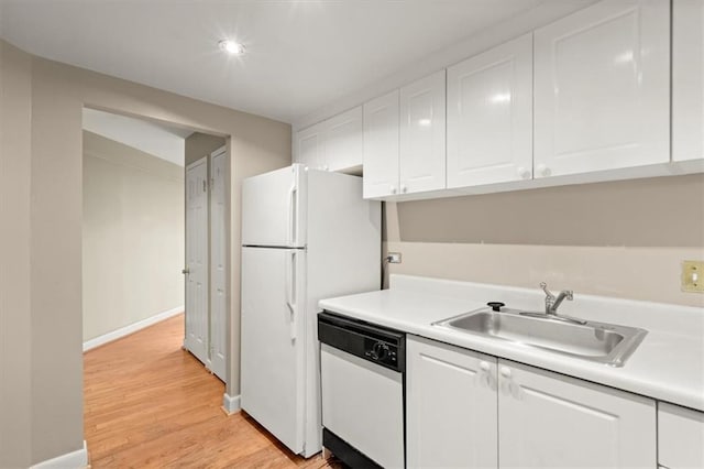 kitchen featuring light countertops, light wood-style floors, white cabinetry, a sink, and white appliances