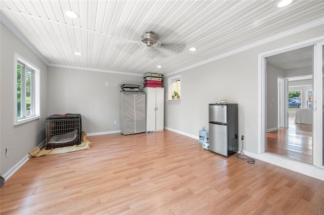 interior space with freestanding refrigerator, crown molding, recessed lighting, light wood-style floors, and baseboards
