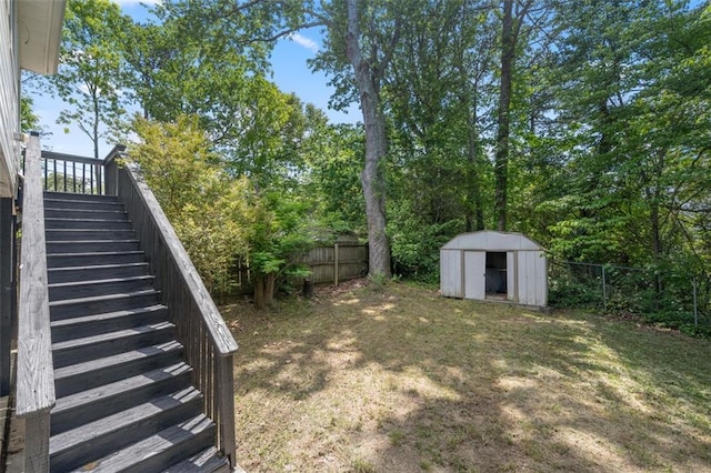fenced backyard with stairway, a shed, and an outbuilding