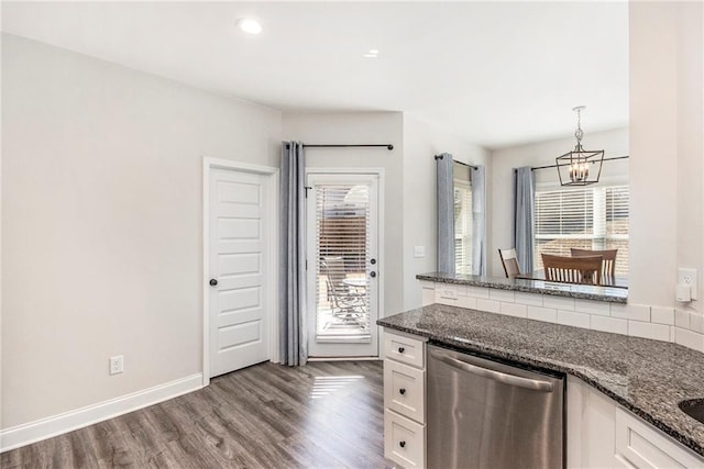 kitchen with dark stone counters, decorative light fixtures, dishwasher, and white cabinets