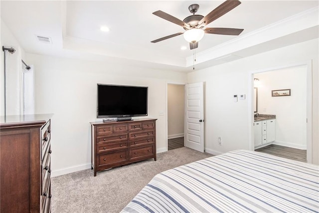 carpeted bedroom featuring ceiling fan, connected bathroom, and a raised ceiling