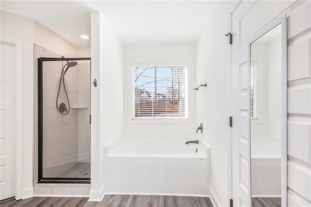 bathroom with shower with separate bathtub and hardwood / wood-style floors