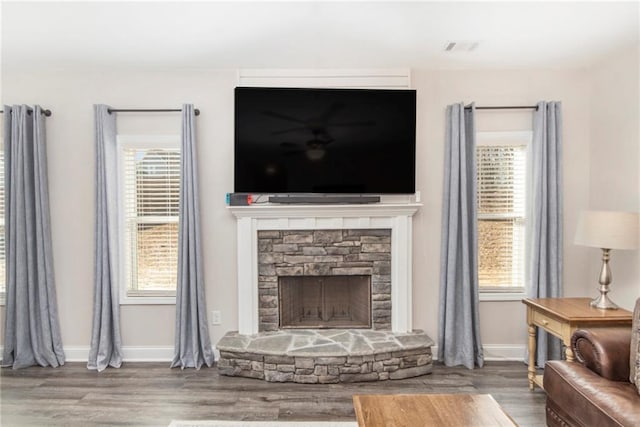 living room with hardwood / wood-style flooring and a stone fireplace