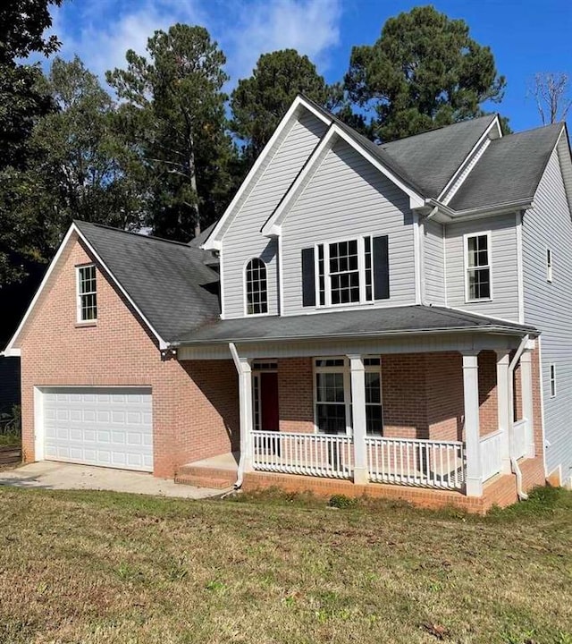 view of front of property with a garage, covered porch, and a front lawn