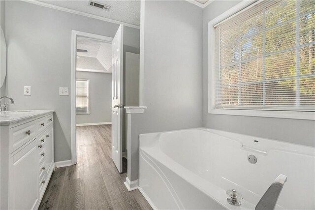 bathroom featuring vanity, hardwood / wood-style floors, crown molding, and toilet