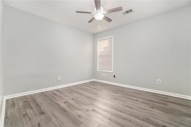 spare room with hardwood / wood-style floors and ceiling fan