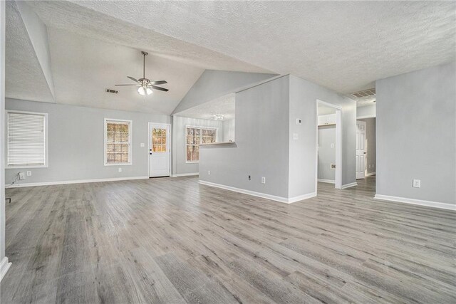 unfurnished living room featuring hardwood / wood-style floors, vaulted ceiling, and ceiling fan