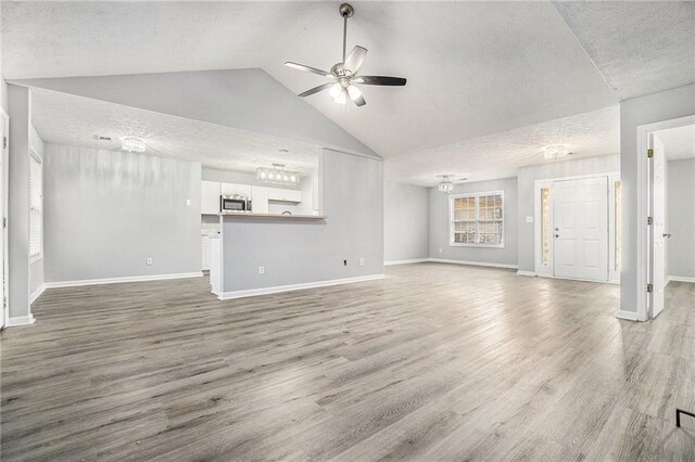 empty room featuring hardwood / wood-style flooring, a chandelier, and a textured ceiling