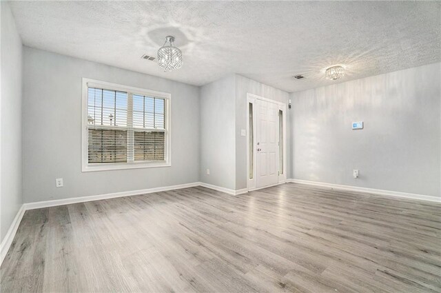 kitchen featuring sink, stainless steel appliances, a textured ceiling, white cabinets, and light wood-type flooring