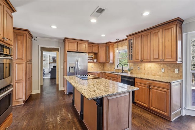 kitchen with brown cabinetry, visible vents, black appliances, and light stone countertops