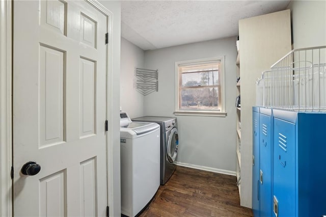 laundry room featuring a textured ceiling, laundry area, dark wood finished floors, baseboards, and washing machine and clothes dryer