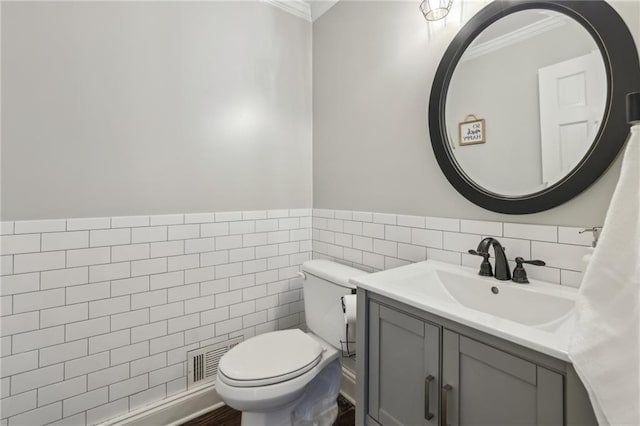 bathroom with toilet, vanity, visible vents, tile walls, and crown molding