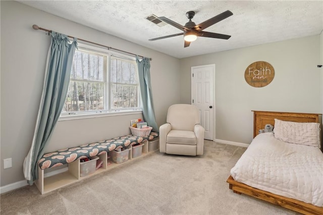 bedroom with a textured ceiling, ceiling fan, carpet flooring, visible vents, and baseboards