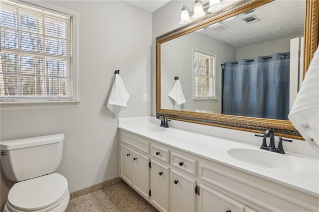 full bathroom with baseboards, visible vents, a sink, and toilet