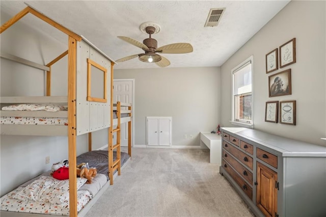 bedroom with a ceiling fan, visible vents, light carpet, and baseboards