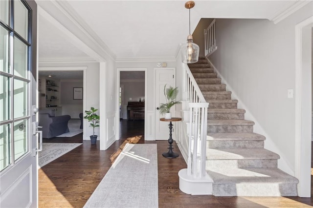 foyer featuring crown molding, dark wood finished floors, and stairway