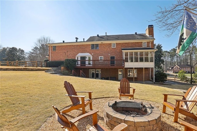 exterior space with a fire pit, a deck, and a sunroom