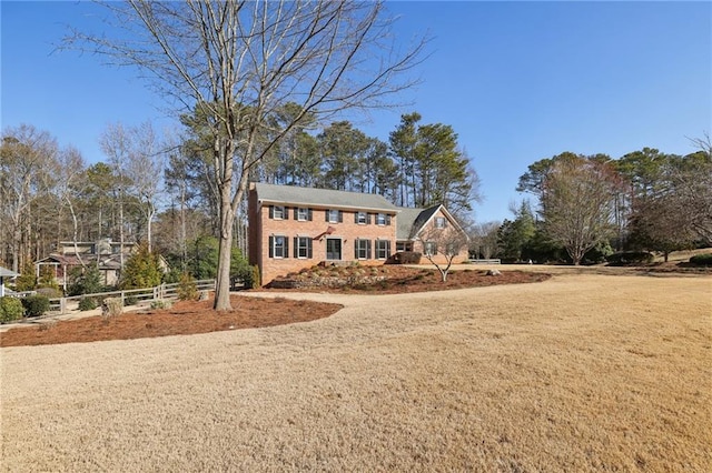 colonial house with a front lawn and fence