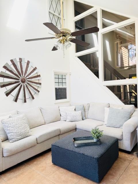 tiled living room featuring a high ceiling and ceiling fan