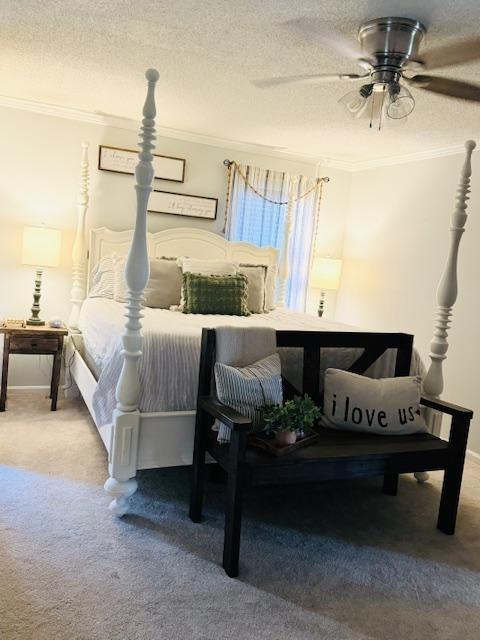 bedroom featuring ceiling fan, carpet floors, a textured ceiling, and ornamental molding