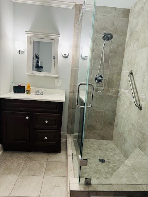 bathroom with tile patterned flooring, vanity, and a shower with door