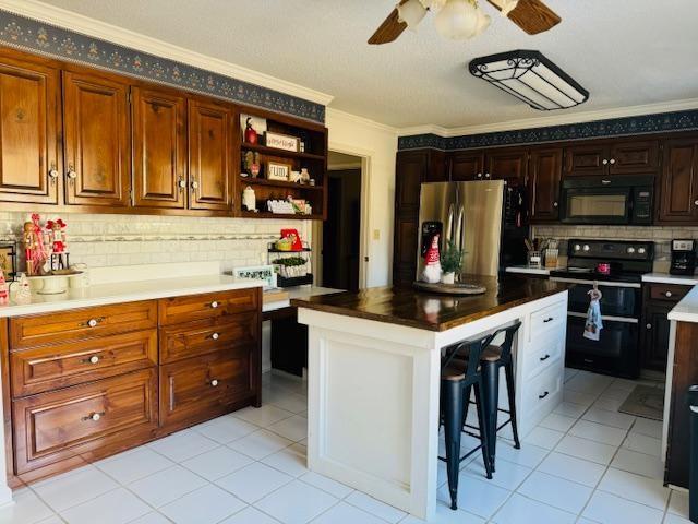 kitchen featuring black appliances, a center island, a breakfast bar area, and tasteful backsplash